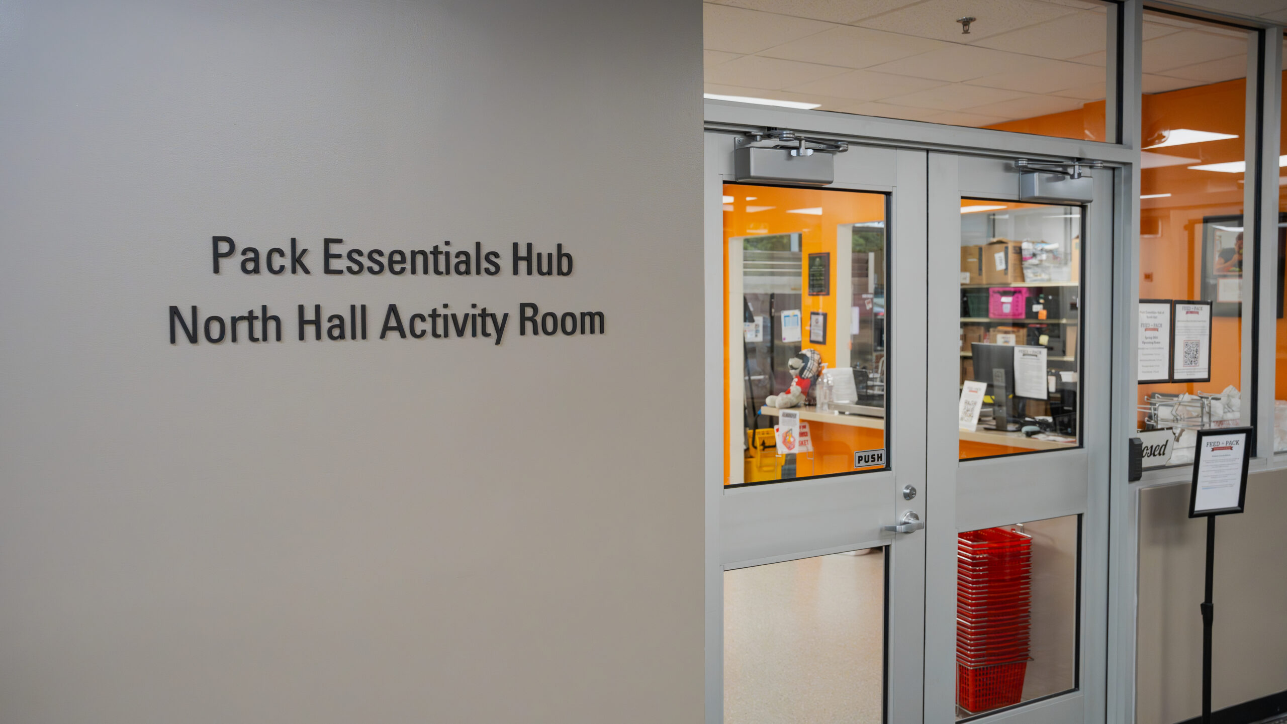 The Pack Essentials Hub sign in the North Hall Activity Room. Feed the Pack Food Pantry is located in the Pack Essentials Hub.
